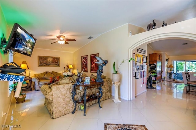 tiled living room with ceiling fan and vaulted ceiling