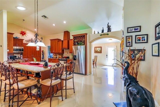 dining room with a wealth of natural light, light tile patterned flooring, and lofted ceiling