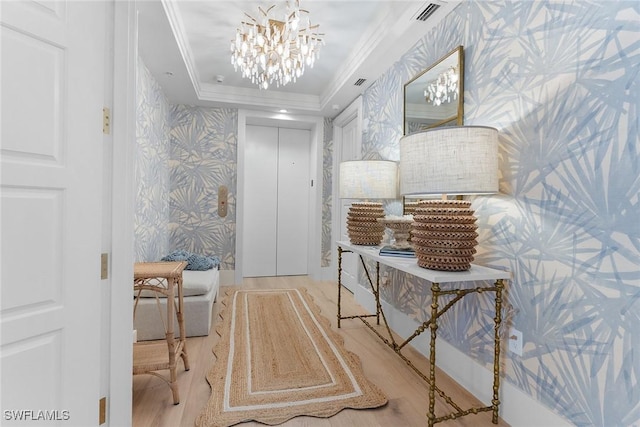 interior space with crown molding, elevator, a tray ceiling, and a chandelier