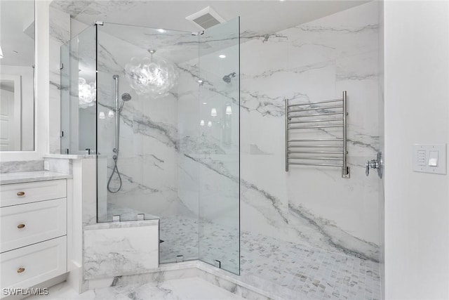 bathroom with radiator, vanity, and tiled shower