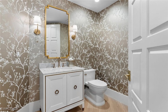 bathroom featuring vanity, hardwood / wood-style flooring, and toilet