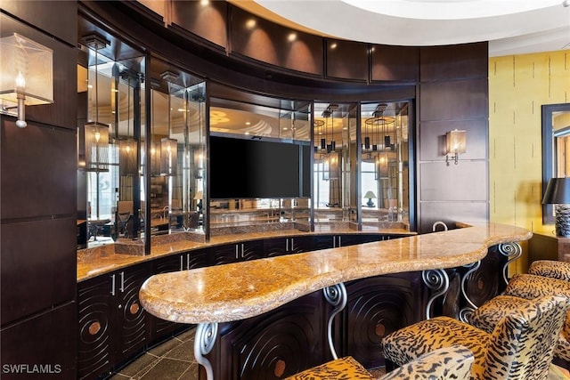 bar with tile patterned floors and light stone countertops