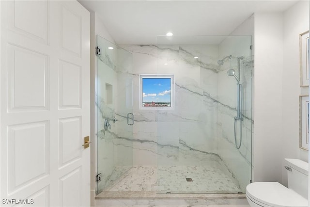 bathroom with a shower with door and toilet