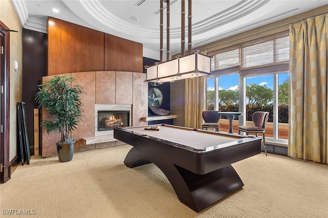 recreation room with crown molding, pool table, light carpet, a tray ceiling, and a tile fireplace