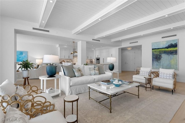 living room featuring beamed ceiling and light wood-type flooring