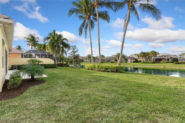 view of yard with a water view and a lanai