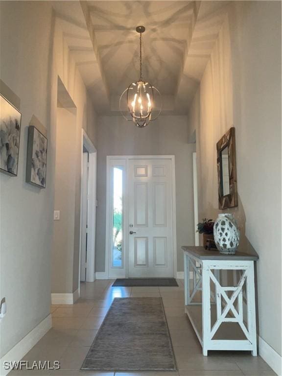 foyer entrance featuring tile patterned floors and an inviting chandelier