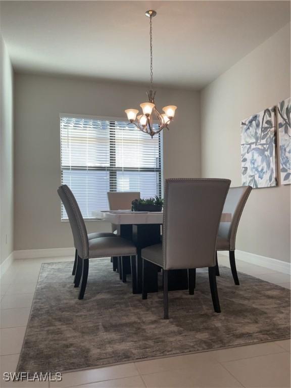 dining room featuring tile patterned flooring and a notable chandelier