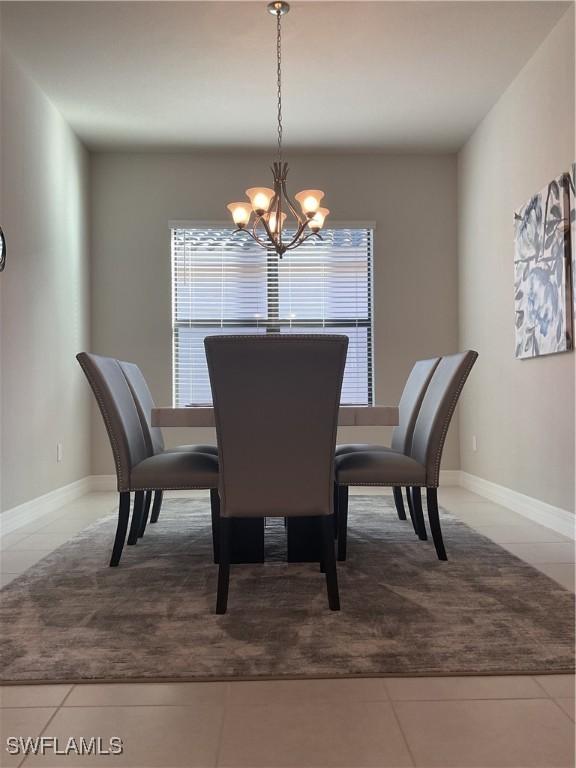 tiled dining space featuring a chandelier