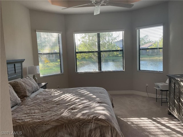 carpeted bedroom with multiple windows and ceiling fan