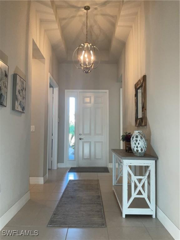 tiled foyer entrance with a notable chandelier