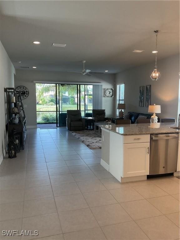 kitchen with stainless steel dishwasher, light tile patterned flooring, white cabinets, and hanging light fixtures