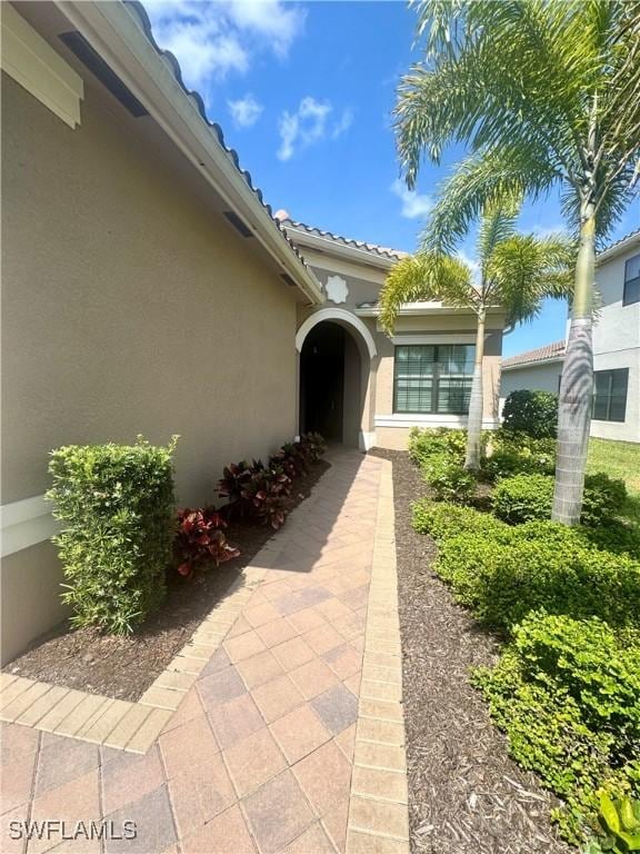 property entrance featuring stucco siding and a tiled roof
