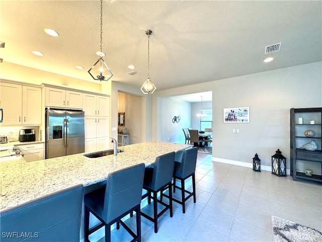 kitchen featuring a sink, visible vents, recessed lighting, and stainless steel fridge with ice dispenser