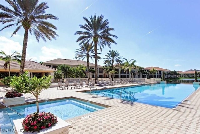 view of swimming pool with a water view and a patio area