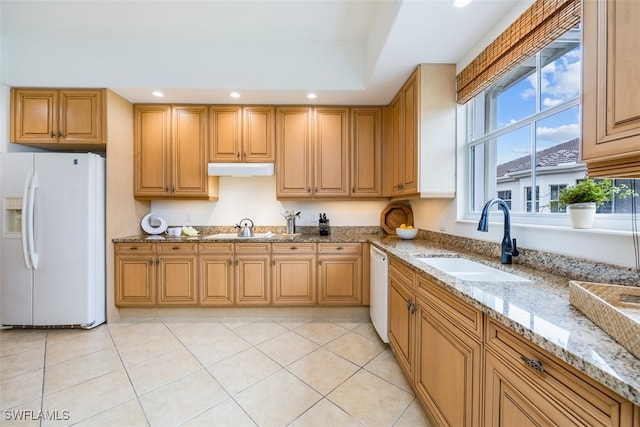 kitchen featuring white appliances, light stone counters, sink, and light tile patterned floors