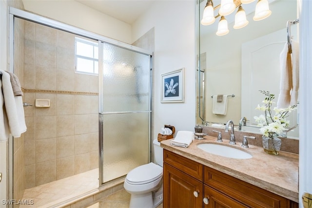 bathroom featuring a shower with shower door, toilet, tile patterned floors, vanity, and a notable chandelier