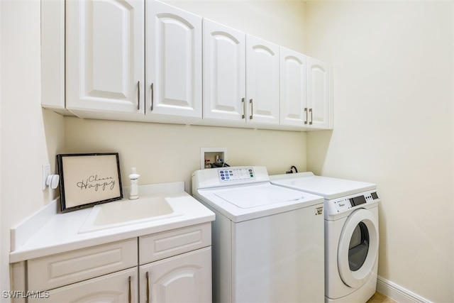 laundry area with washer and dryer, cabinets, and sink