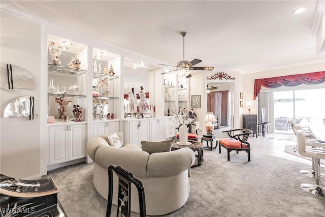 living room with ceiling fan, light colored carpet, and ornamental molding