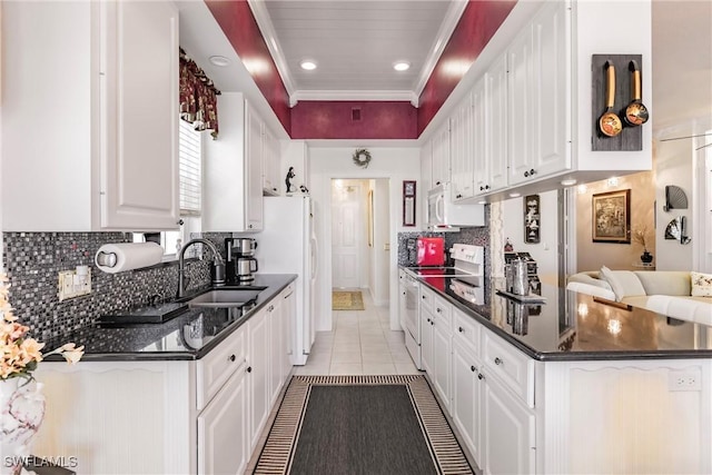 kitchen featuring stainless steel range with electric stovetop, sink, light tile patterned floors, tasteful backsplash, and white cabinetry