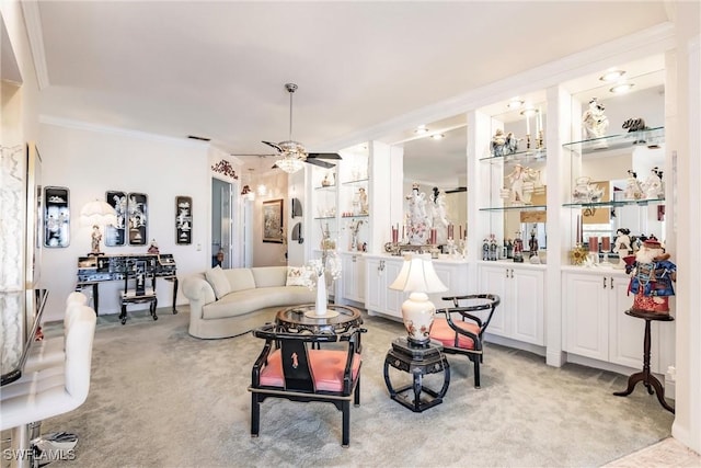 living room with ceiling fan, light colored carpet, and ornamental molding