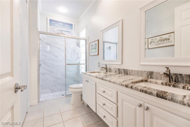 bathroom featuring tile patterned floors, vanity, crown molding, toilet, and a shower with shower door