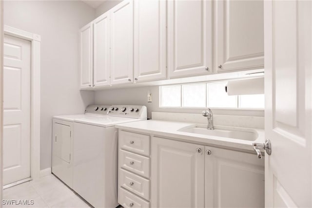 laundry area with separate washer and dryer, sink, light tile patterned floors, and cabinets