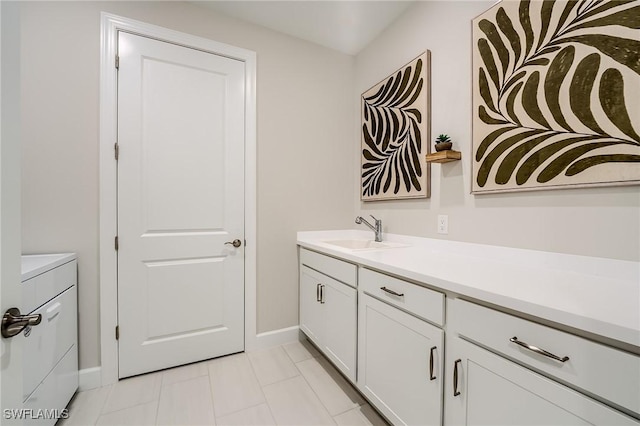 bathroom with tile patterned floors, vanity, and washer / dryer