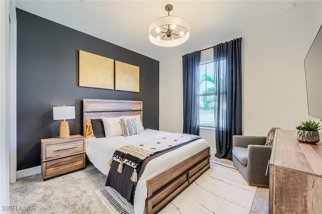 carpeted bedroom featuring an inviting chandelier