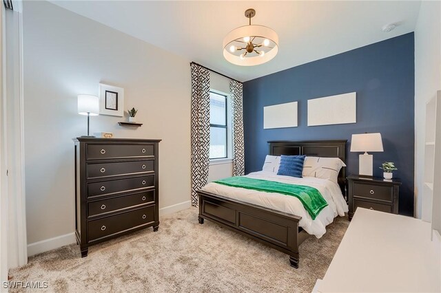 carpeted bedroom with an inviting chandelier