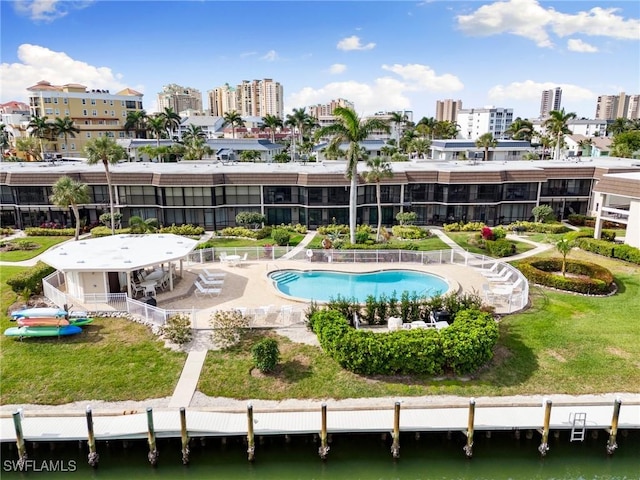 view of pool featuring a yard, a water view, and a patio