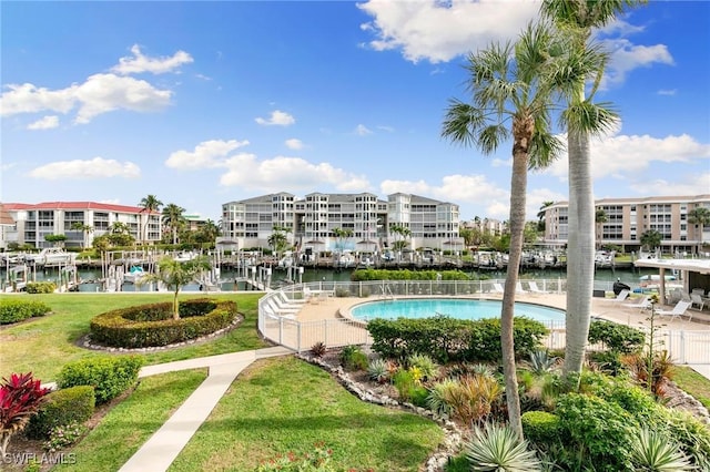 view of pool with a water view and a yard