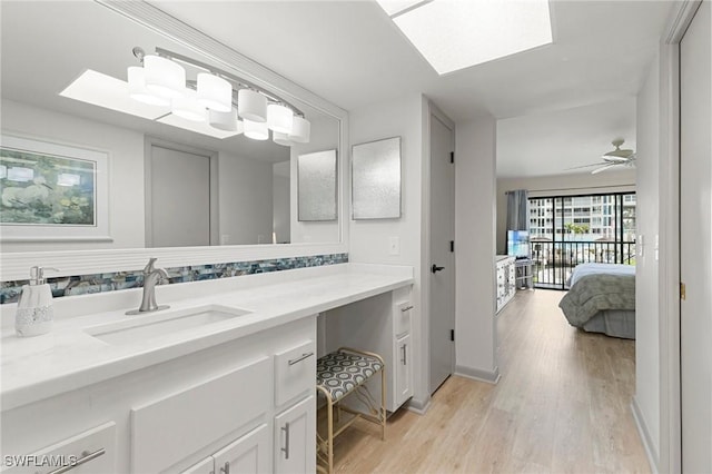 bathroom featuring hardwood / wood-style floors, ceiling fan, and vanity