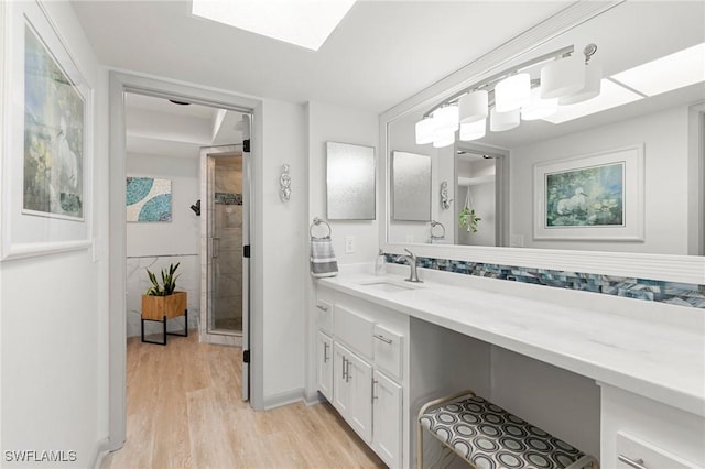 bathroom with hardwood / wood-style flooring, vanity, and a shower with door