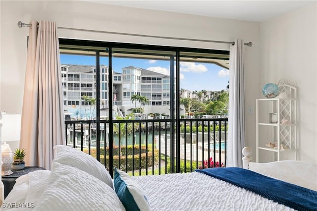 bedroom featuring access to exterior, a water view, and multiple windows