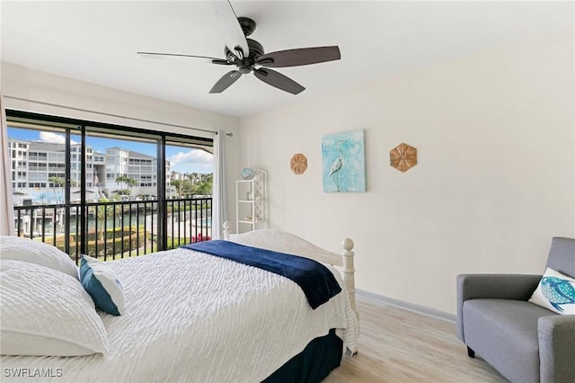 bedroom featuring ceiling fan, access to exterior, light wood-type flooring, and a water view