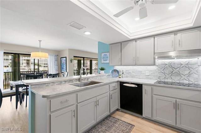 kitchen featuring kitchen peninsula, gray cabinetry, sink, black appliances, and pendant lighting