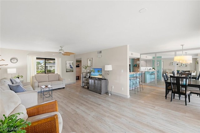 living room featuring light wood-type flooring and ceiling fan