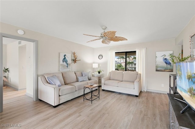 living room featuring ceiling fan and light hardwood / wood-style floors