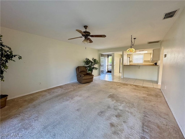 unfurnished living room featuring ceiling fan and light colored carpet