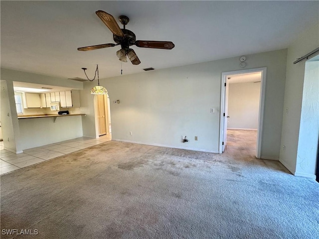 unfurnished living room with ceiling fan and light colored carpet