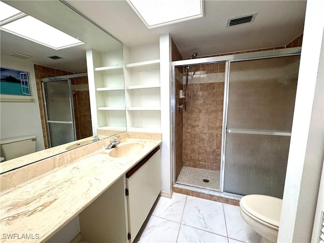 bathroom with vanity, toilet, and a shower with shower door