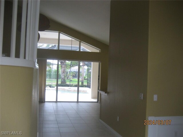 spare room with tile patterned floors and lofted ceiling