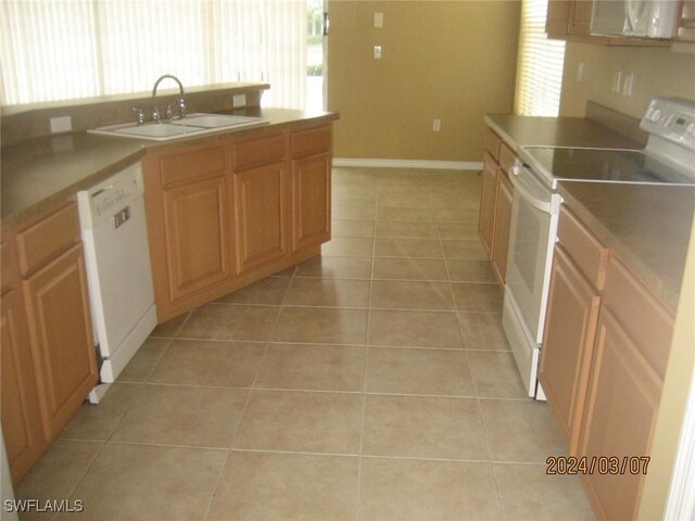 kitchen featuring sink, white appliances, and light tile patterned floors