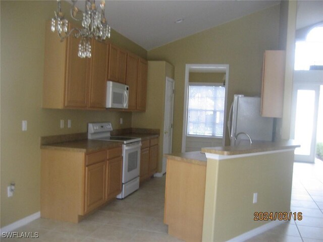 kitchen with white appliances, kitchen peninsula, a chandelier, vaulted ceiling, and light tile patterned floors