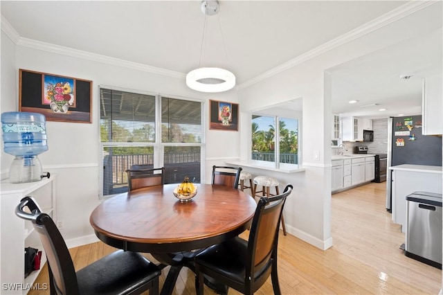 dining area with light wood-type flooring, sink, and ornamental molding