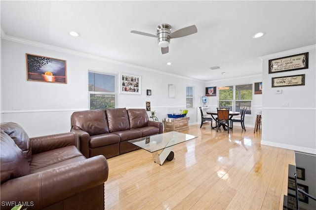 living room featuring light hardwood / wood-style flooring, ceiling fan, and ornamental molding