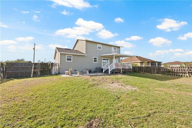 rear view of property featuring a lawn, a wooden deck, and central AC