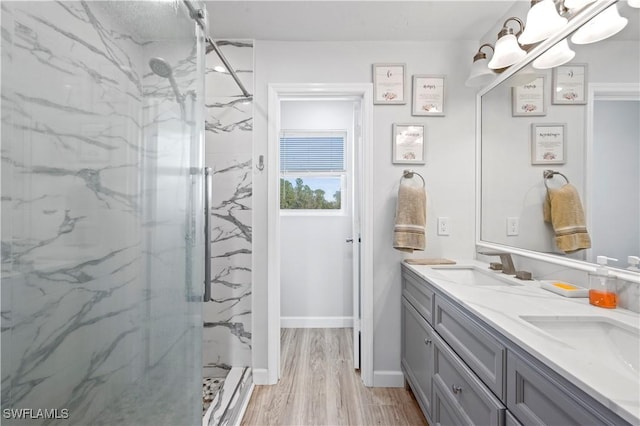 bathroom featuring hardwood / wood-style floors, vanity, and tiled shower