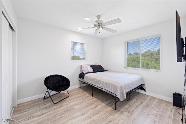 bedroom featuring ceiling fan, a closet, and light wood-type flooring